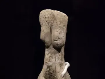Venus of Eliseevichi ivory figurine on a mount against a dark background