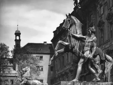 Two bronze Horse Tamers sculptures showing muscular men restraining rearing horses on stone pedestals.