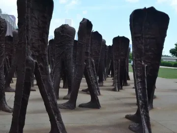 Agora sculpture with numerous dark headless human figures standing together in Grant Park