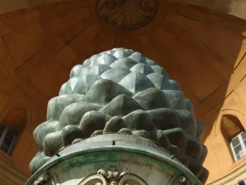 La Pigna sculpture resembling a giant green pine cone in front of a domed building