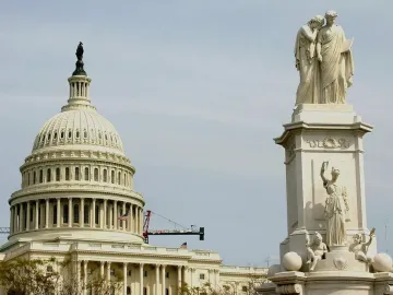 Peace Monument with allegorical figures, set against the U.S. Capitol dome and an overcast sky.