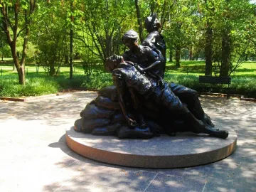 Vietnam Women\'s Memorial bronze sculpture showing two female figures tending a prone figure on a circular stone base.