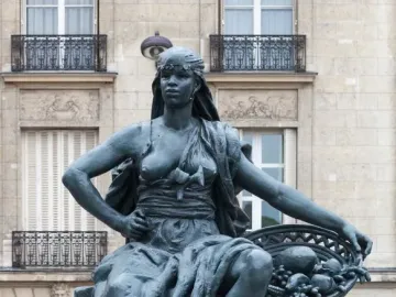 Africa by Eugène Delaplanche, a dark patinated seated woman with a headscarf, flowing drapery, and a basket of fruit, resting her feet on a tortoise.
