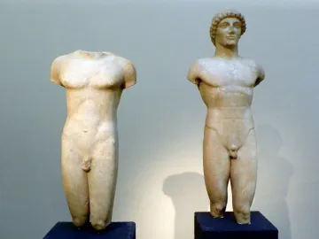 The Strangford Apollo marble statue beside a headless kouros torso, both shown from the chest down.