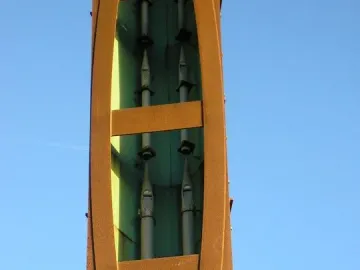 Interior detail of the Blackpool High Tide Organ showing upside-down metal pipes inside a reddish-brown structure.
