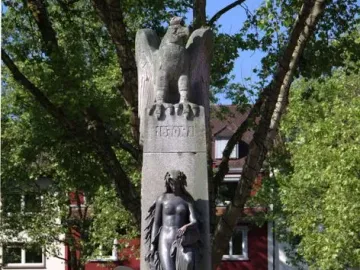 Mutter Kinzig monument with a stone eagle atop a tall shaft and a dark female figure below.