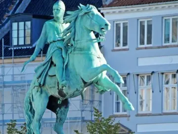 Absalon Monument, a green-patinaed equestrian statue on a brick and stone pedestal with buildings and trees behind it.
