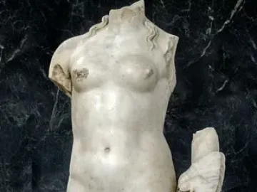 Venus Unica, a headless white stone female nude statue on a rectangular base.