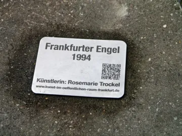 Metal plaque for Frankfurter Engel with the title, year 1994, artist Rosemarie Trockel, website address, and a QR code.