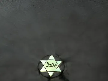 Glowing Star of David with the word Jude inscribed on a dark textured surface.