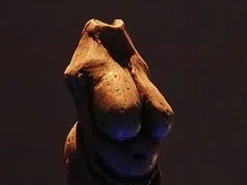 Venus of Moravany figurine with prominent breasts and enlarged abdomen on a clear display base.