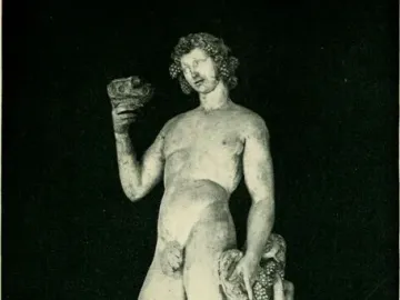 Bacchus statue with grapes in his hair, raising a cup and standing beside a crouching figure reaching for grapes.