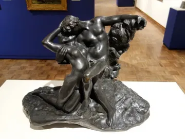 The Eternal Springtime bronze sculpture of a man and woman embracing on a rocky base.