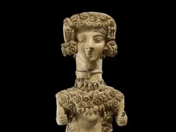 Lady of Ibiza clay figure with an elaborate headdress and intricate scrollwork patterns