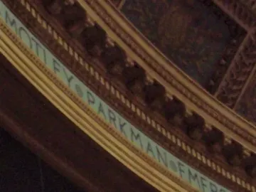Sacred Cod fish sculpture suspended in front of an ornate frieze with engraved text.