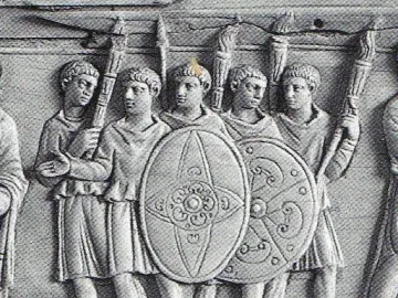 Detail of the Brescia Casket showing five ancient male figures in tunics holding shields and tall objects.