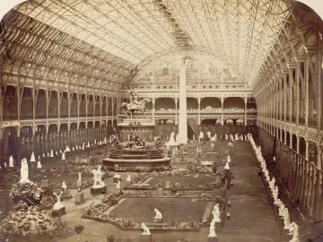Dom Pedro I equestrian statue on a tall pedestal in a vast glass-and-iron exhibition hall, surrounded by smaller sculptures.
