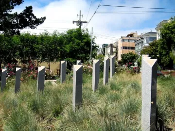Pink Triangle Park memorial columns with triangular caps among tall grasses