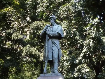 Seventh Regiment Memorial statue of a soldier holding a rifle beside a stone pedestal in Central Park