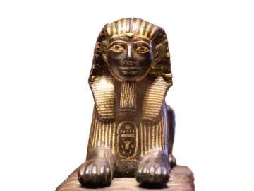 Thutmose III sphinx with a dark body and gold detailing on the headdress, beard, and collar