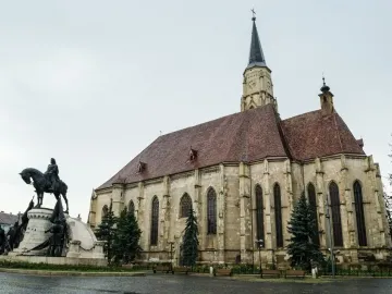 Matthias Corvinus Monument with a bronze equestrian statue and smaller bronze figures in front of a historic church