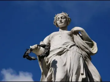 Titanic Memorial statue of a woman holding a laurel wreath against a blue sky