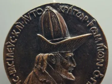 Medal of John VIII Palaiologos showing a bearded profile bust with a tall pointed hat and Greek inscription around the edge.