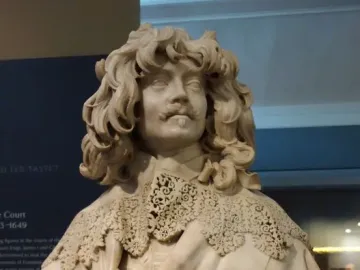 Bust of Thomas Baker with curly hair, a mustache, and an elaborate lace collar.