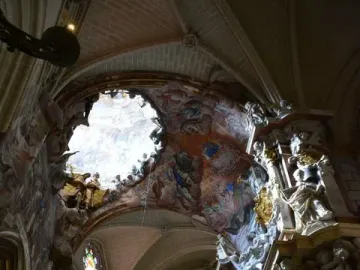 The Transparente in Toledo Cathedral, with a bright opening in the ceiling above an ornate sculpted altar and vaulted arches.