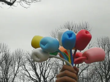 Bouquet of Tulips sculpture showing a giant hand holding colorful tulip-like forms against an overcast sky.