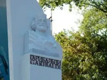 Garibaldi Monument with a bearded bust and floral tribute at the base