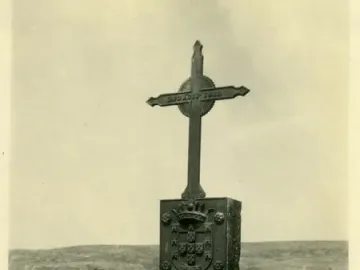 The Padrão de Santa Maria stone pillar with a crowned shield and cross on top, standing in a barren landscape.