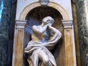 Saints Jerome and Mary Magdalen in white marble, shown in an ornate arched niche with the figure in a contemplative pose.