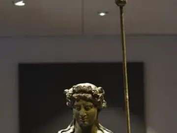 Tiber Dionysus bronze statue of a nude male figure holding a staff and wearing a wreath.