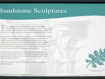 Informational sign for the Capitol Columns with text and a teal acanthus leaf graphic.