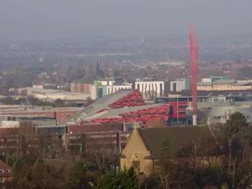 Aspire, a tall red sculpture of interwoven beams rising above the campus buildings and trees.