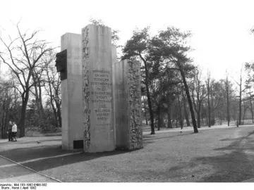 Julius Fučík Memorial with tall steles, a dark profile bust, and an inscribed panel in a park setting.