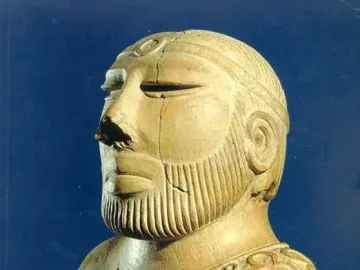 Bust of the Priest-King showing a bearded man in profile with carved facial hair and a patterned cloak.