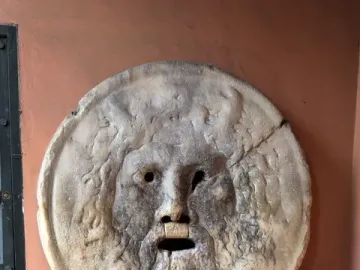 Bocca della Verità stone face with a wide open mouth and weathered surface