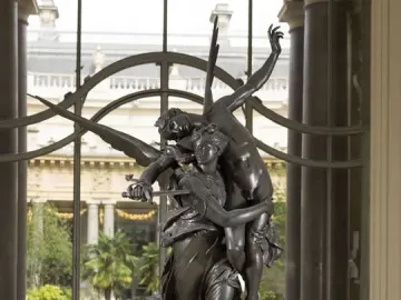 Gloria Victis bronze sculpture of a winged female figure carrying a fallen male warrior on a pedestal.