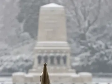 A guardsman stands in the snow facing the Guards Memorial in Whitehall.