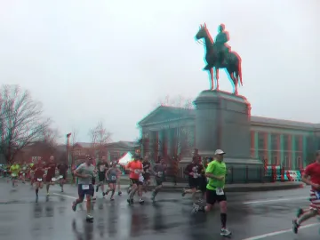 Robert E. Lee Monument with runners on a wet street in front of an equestrian statue on a tall stone base.