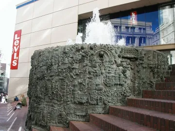 San Francisco Fountain with water spraying from a dark metallic sculptural structure beside brick steps.