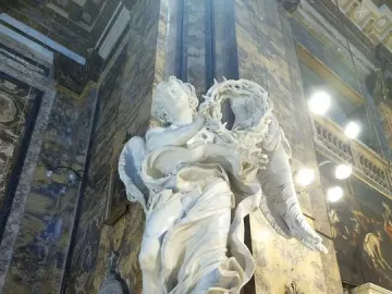 Bernini\'s Angel with the Crown of Thorns, a white marble angel sculpture holding a thorny wreath inside a church interior.