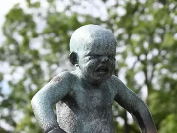 Angry Boy bronze statue of an upset toddler with clenched fists and a furrowed expression.