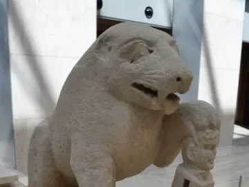 Bear of Porcuna stone sculpture showing a seated animal with one paw resting on a carved human-headed pillar.