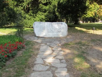 Keys Handover Memorial stone monument with Cyrillic inscription and bas-relief figures in a park