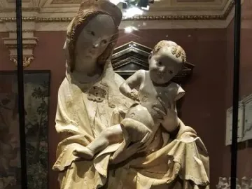 Krumlov Madonna sculpture of a woman holding a child behind glass in a museum
