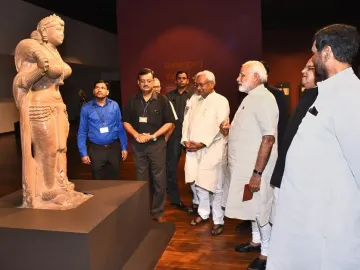 Didarganj Yakshi stone sculpture on a pedestal, with a crowned female figure holding an object and a broken left hand.
