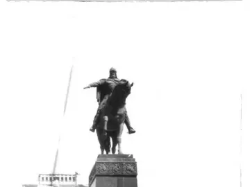 The Monument to Yuri Dolgorukiy, an equestrian statue on a tall pedestal, with trees and a fountain in the background.